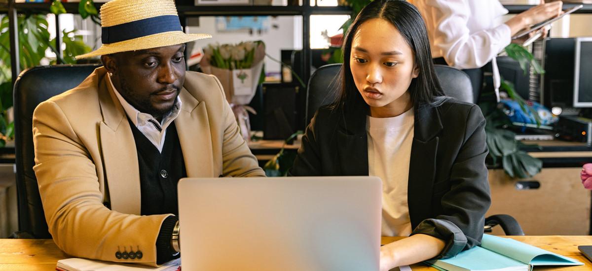 Man and woman sat at laptop